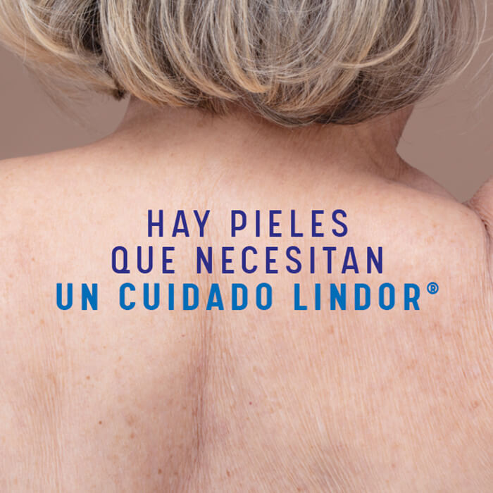 Espalda de mujer donde dice la frase "Hay pieles que necesitan un cuidado Lindor"