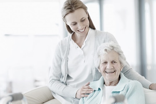Mujer sonriendo con su madre mayor